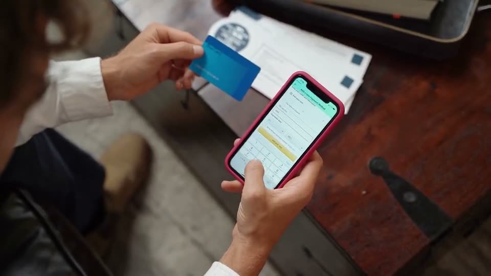 Wisewallee project — hands holding a bank card and a phone showing a payments app